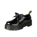 Women's white and black thick soled leather shoes with cross strap and ribbon detail on a superfine fibre upper.
