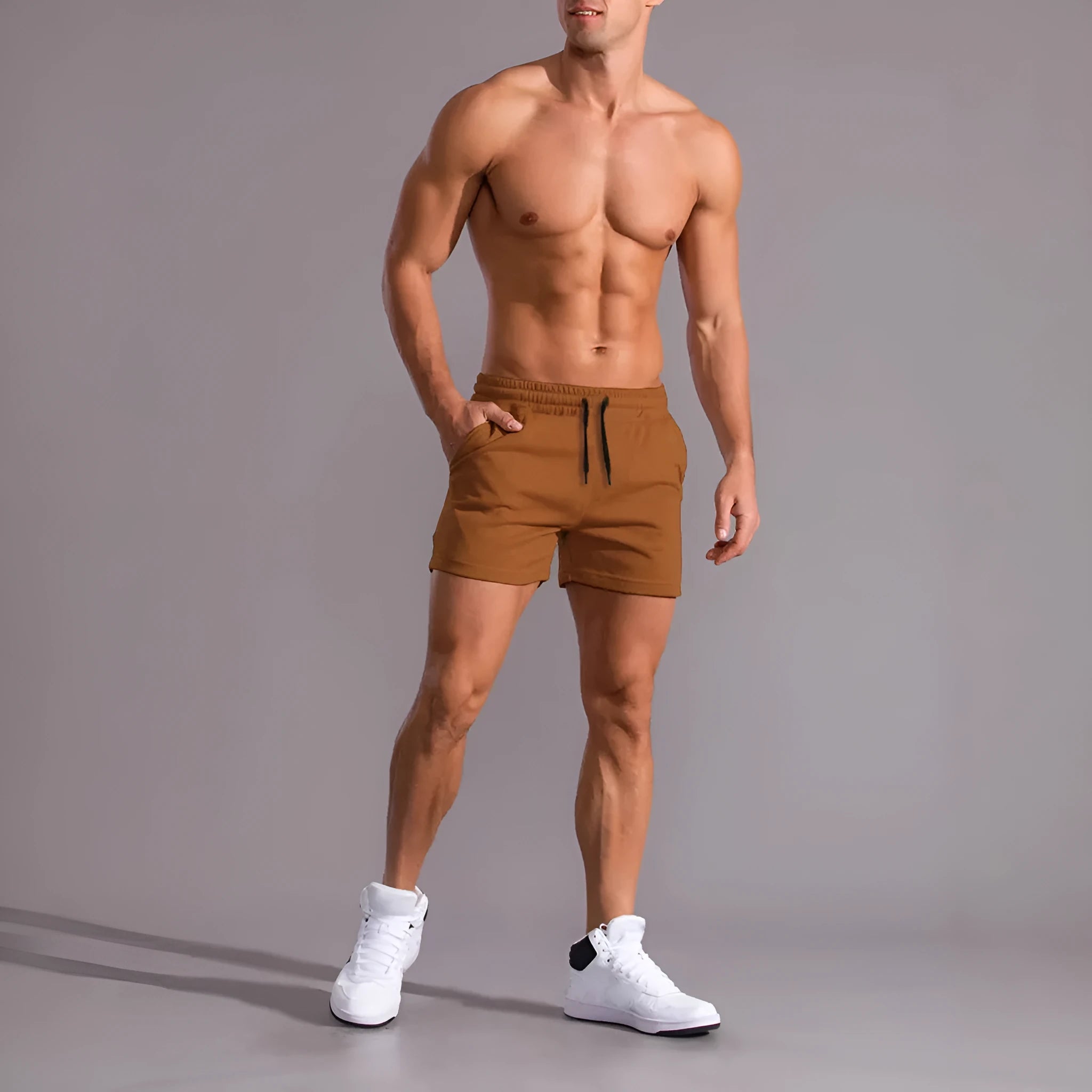 Pack of three men's solid colour drawstring shorts in black, khaki, and light brown on a hanger