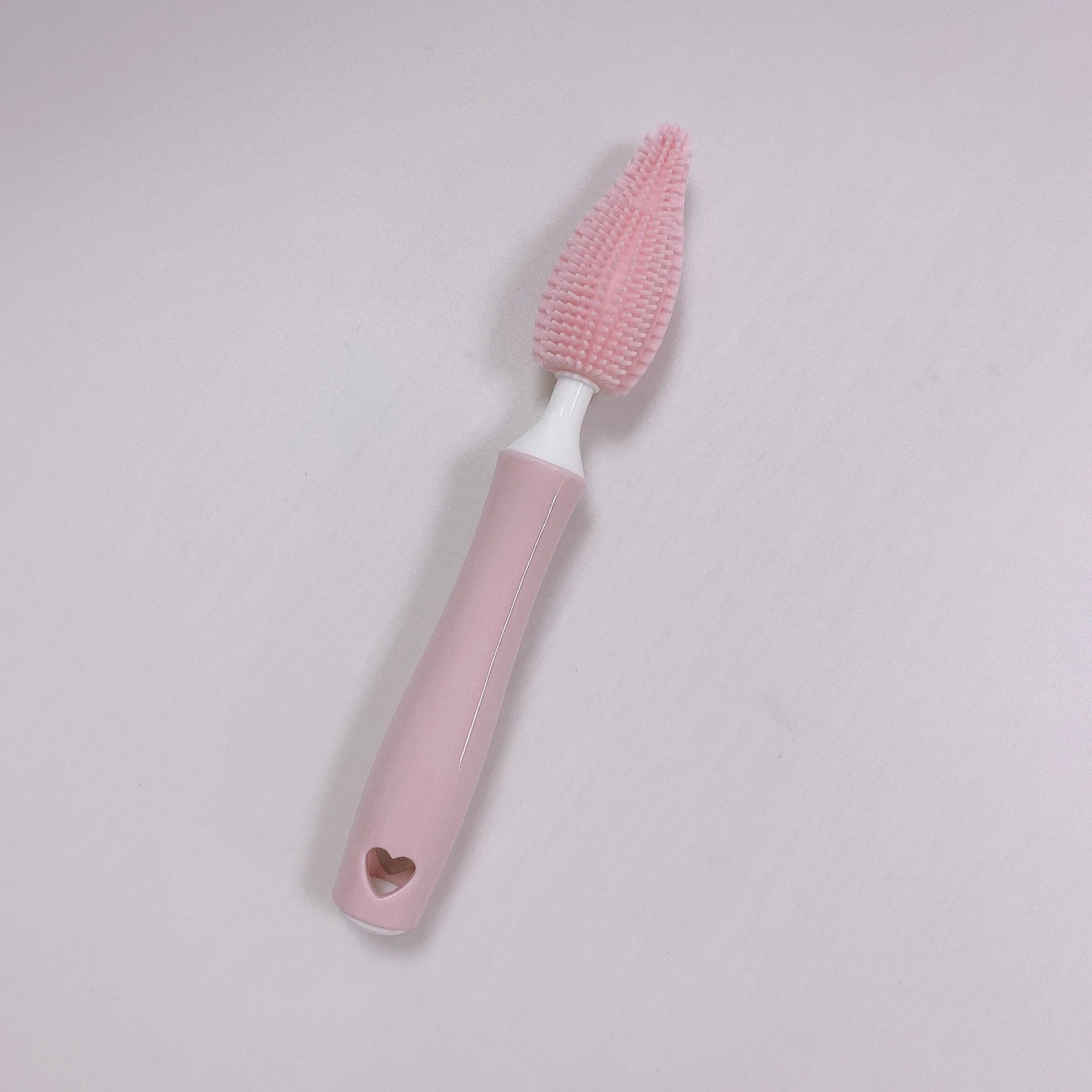 Blue, pink, and yellow silicone baby bottle brushes with an integrated straw cleaning tool.