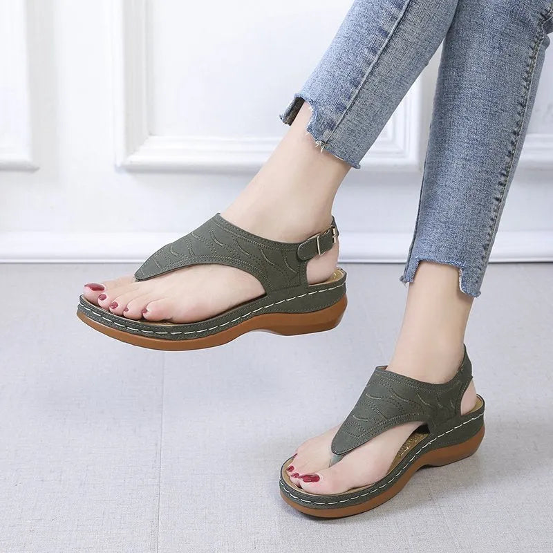 Women's wedge heel flip flop sandals in black with an adjustable buckle strap on the back.