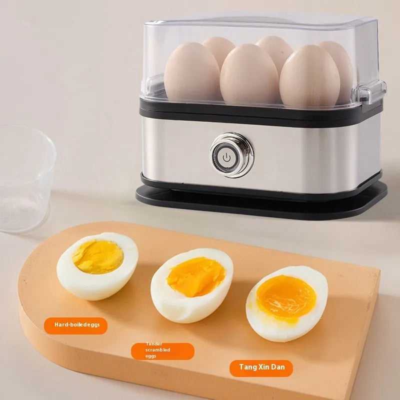 Black portable stainless steel egg boiler with carrying belt on a table.