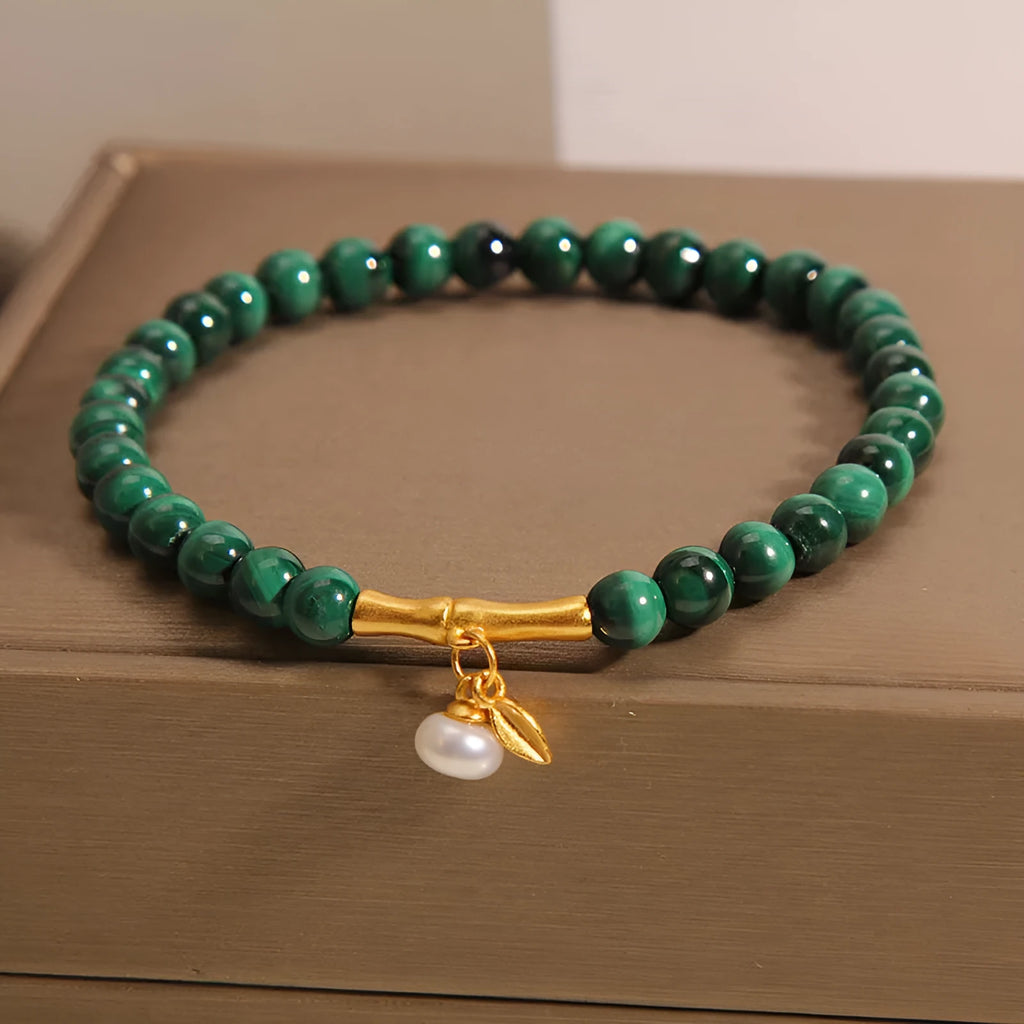 A women's adjustable bracelet made of white crystal with a lucky bamboo charm on the wrist.