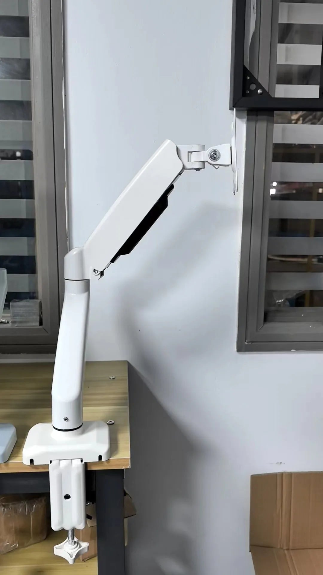 Black rotating telescopic LCD screen bracket on table with adjustable height and swivel features