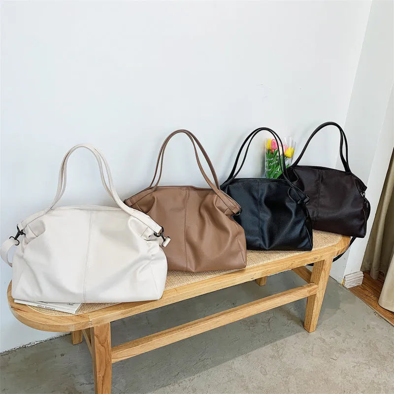 Large horizontal soft PU messenger bag in black with zip opening and long shoulder strap.