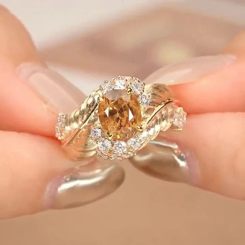 Gold women's feather ring with embossed geometric design and yellow zircon stone